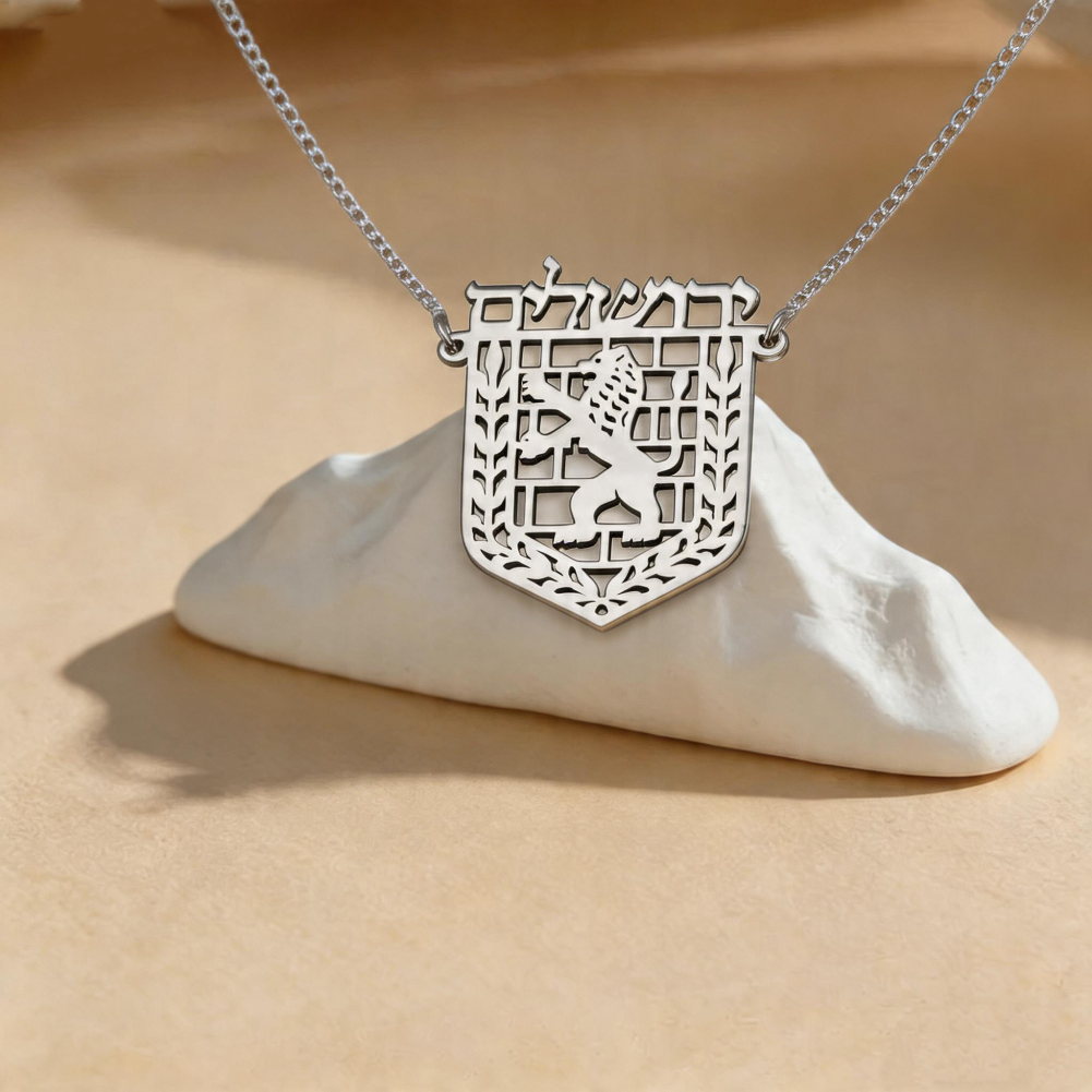 Collier Jérusalem argenté posé sur un support minéral blanc
