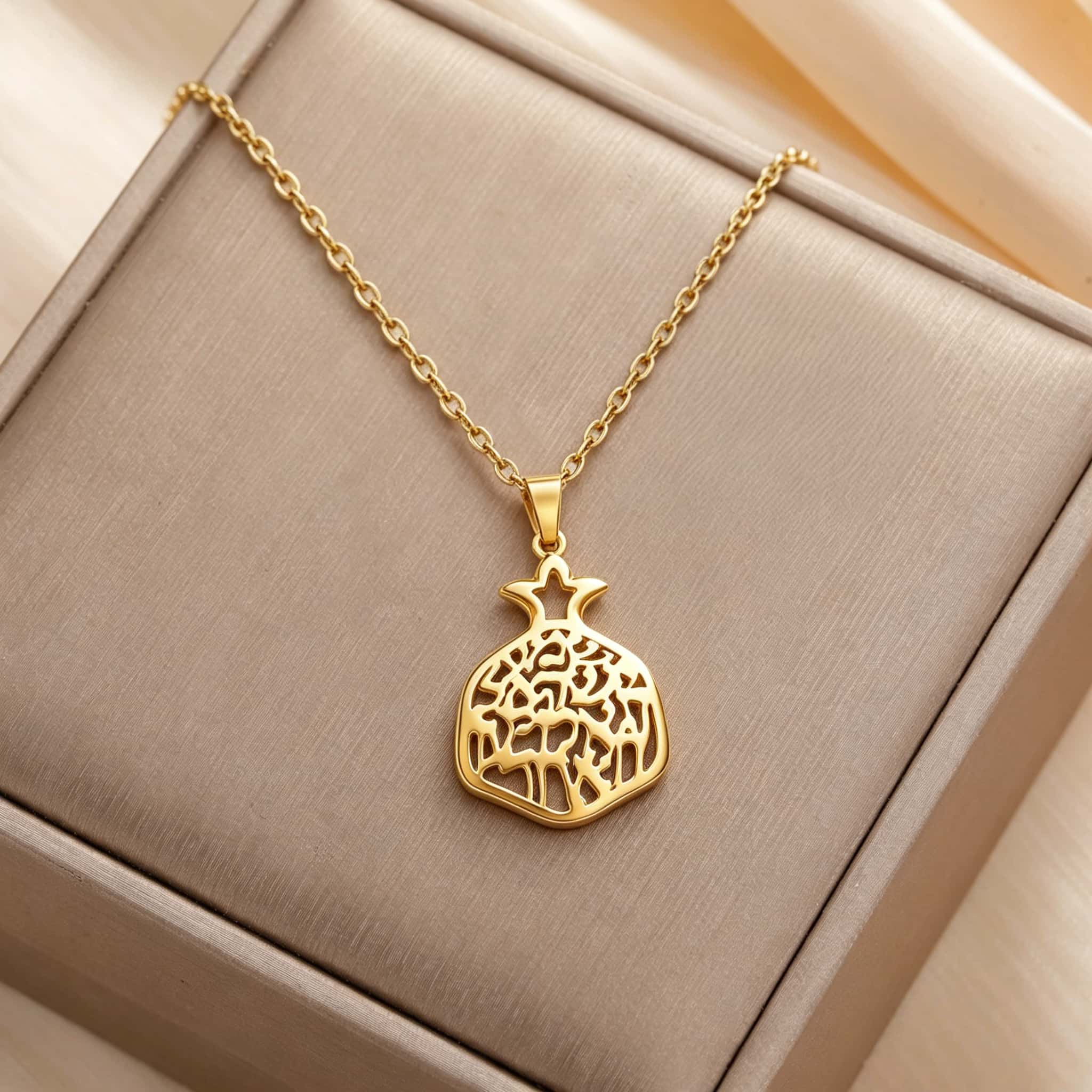 Collier grenade arbre de vie doré présenté sur écrin beige