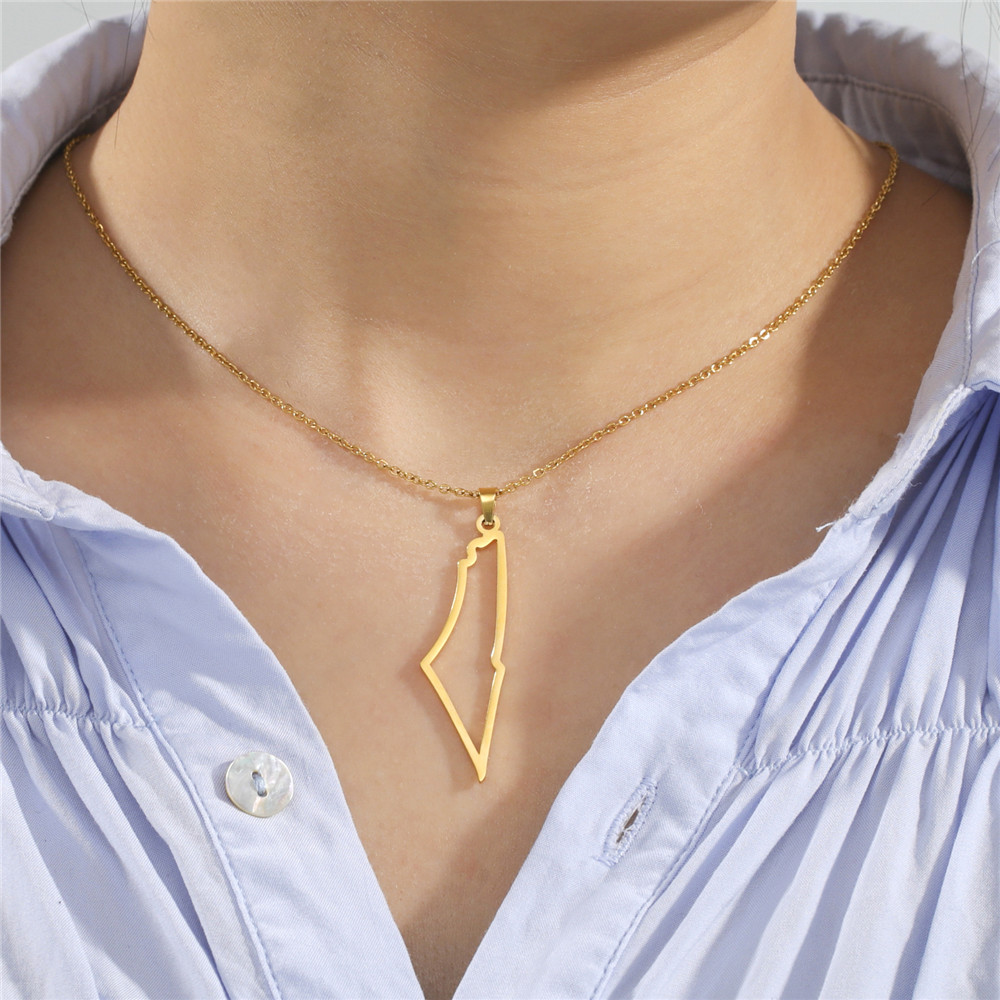 Collier carte d’Israël doré porté sur une chemise bleu clair
