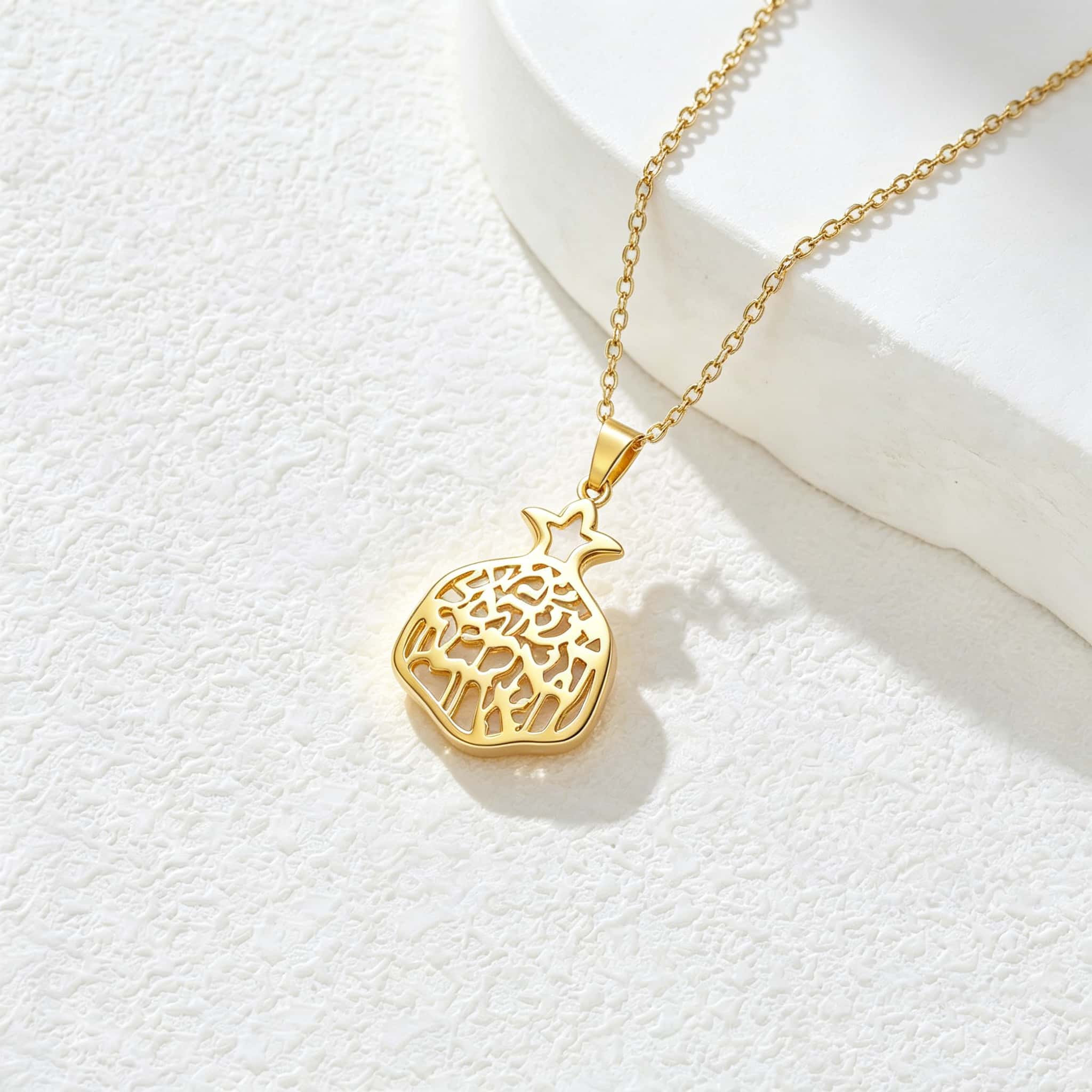 Pendentif grenade doré ajouré en lumière naturelle