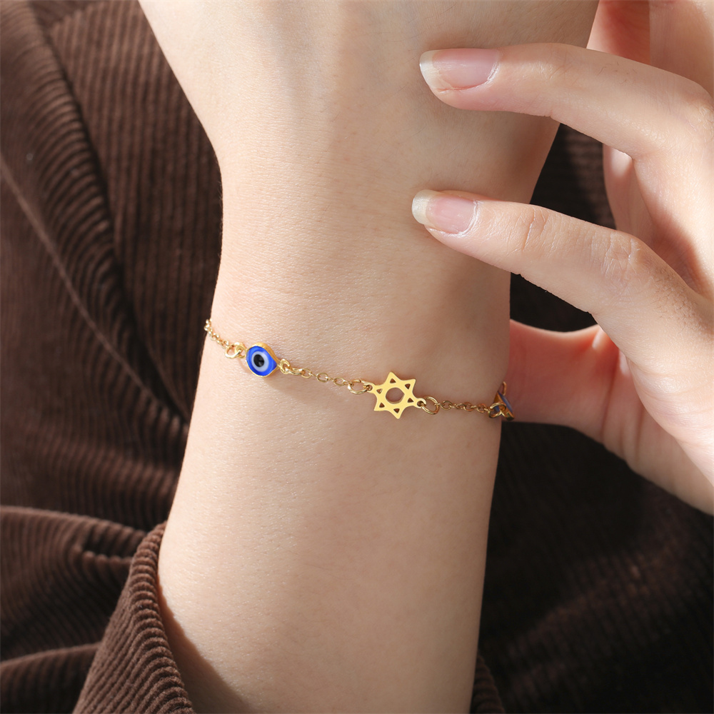Bracelet doré à œil bleu porté au poignet