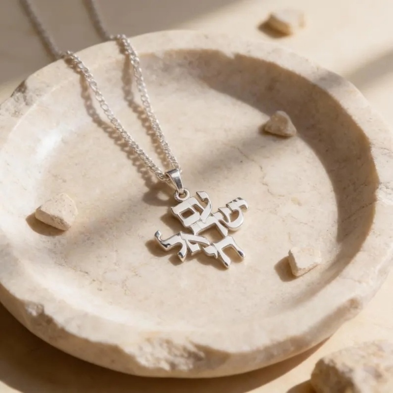 Pendentif argenté Am Israël Chaï, silhouette hébraïque ajourée sur chaîne fine.